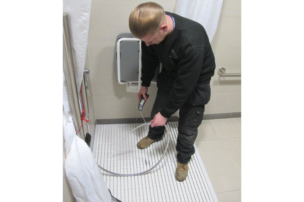 Man testing water temperature of a shower