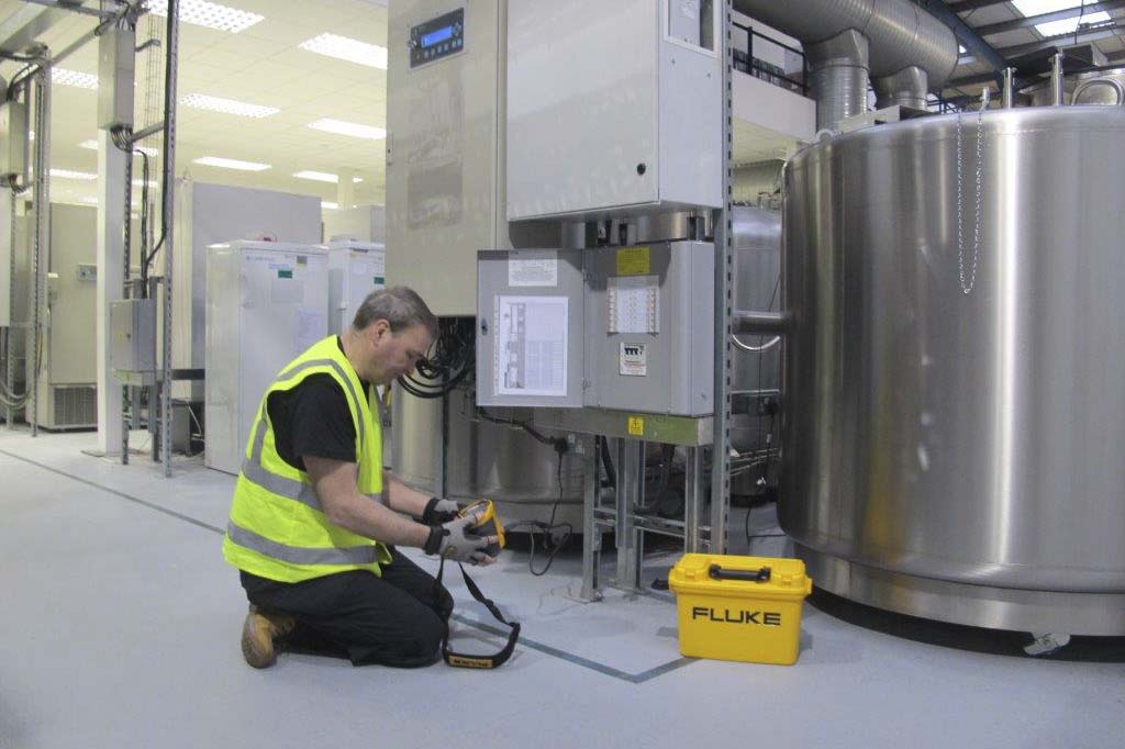 Man testing electrical equipment in a warehouse